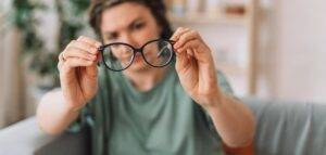 woman holding up pair of glasses